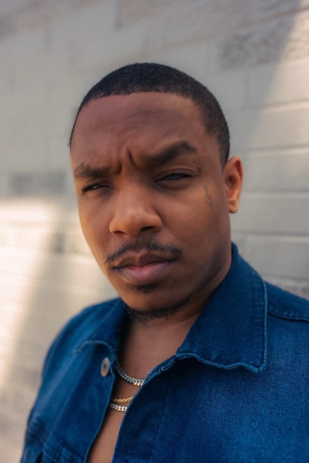 Joseph Johnson (Speezy OTB), founder of International Playing Field, in a close-up portrait against a white wall